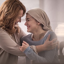 happy mother and sick adult daughter in kerchief hugging and looking at each other